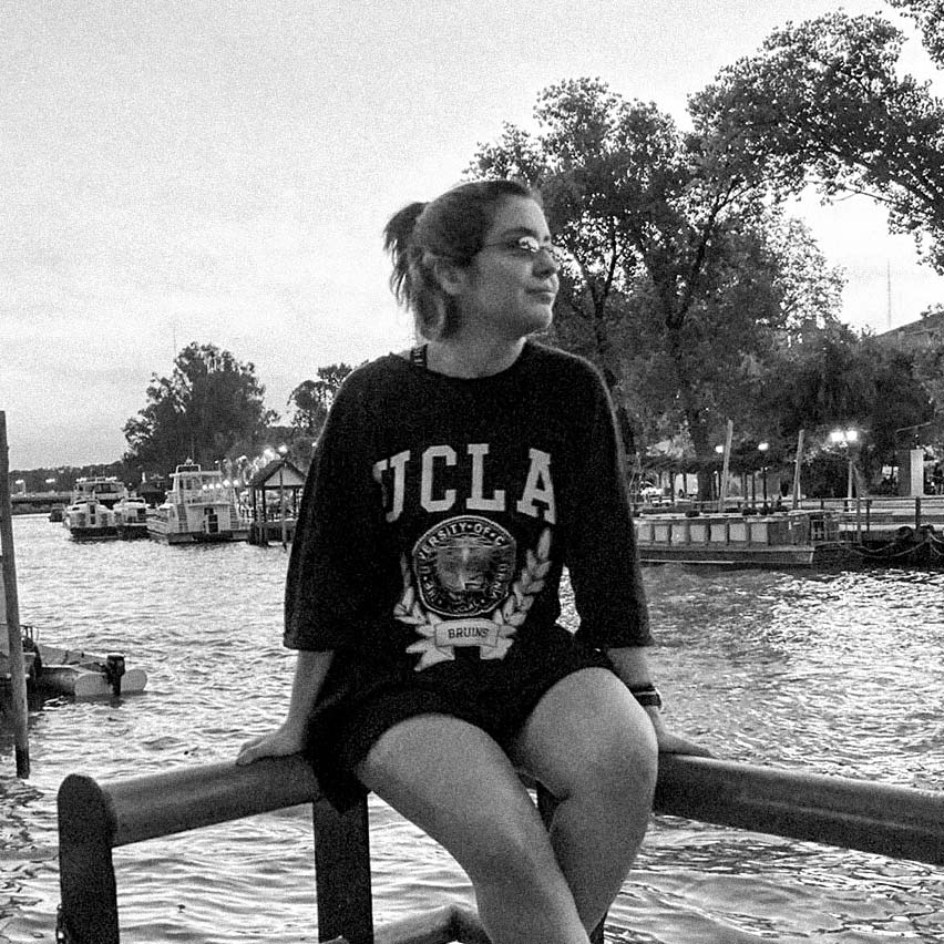 Una chica de frente con una cascada de fondo.