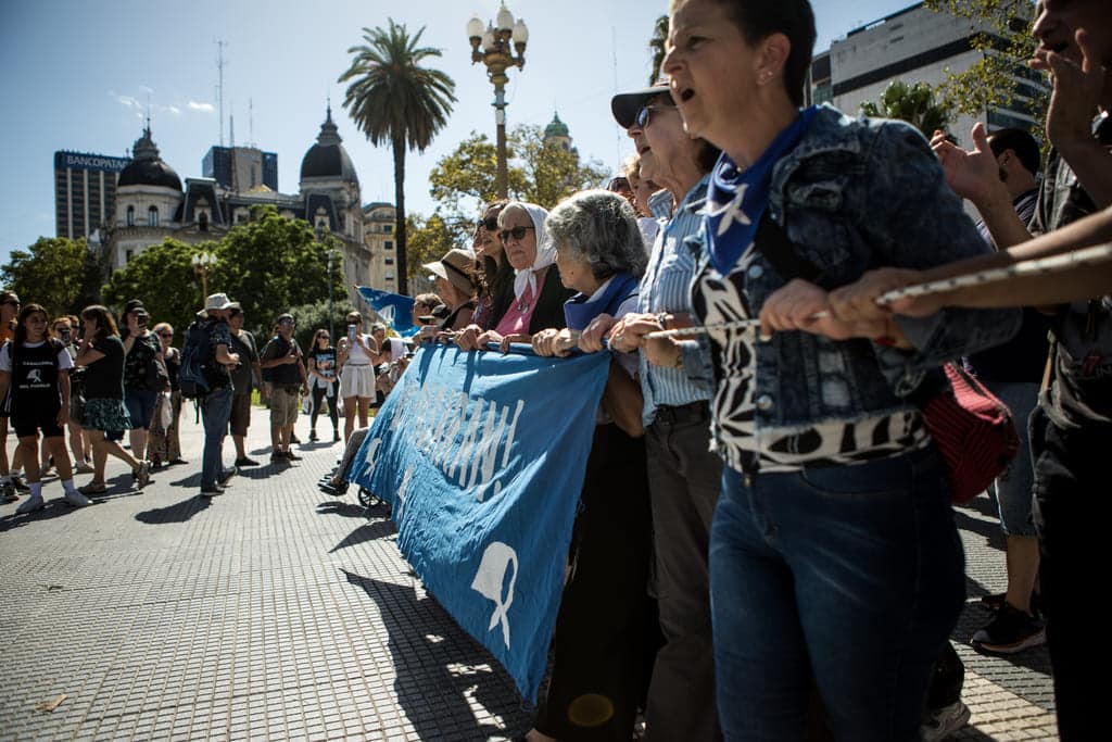 Fotografía de la bandera con todos los retratos de los desaparecidos.